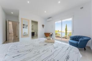 a large white bedroom with a large bed and a blue chair at Modern villa with great location in Ciudad Quesada +22 photos