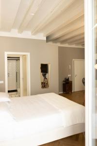 una camera da letto con un grande letto bianco e una televisione di IL NIDO DI IRENA A VERONA a Verona