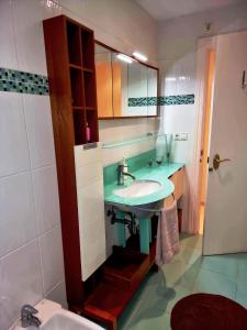 W łazience znajduje się umywalka i lustro. w obiekcie APARTAMENTO EN PRIMERA LINEA DE PLAYA CON INCREIBLES VISTAS w mieście Santa Pola