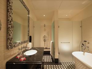a bathroom with a sink and a mirror at The LaLit London in London +104 photos