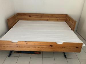 Cama de madera en una esquina de habitación en Appartement Arreau, en Arreau