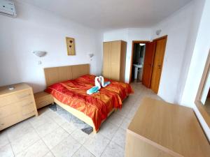 a bedroom with a bed with a red blanket at Vega Village Ap B39 in Sveti Vlas