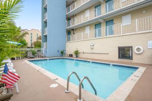 a pool at a hotel with an american flag at Coastal Palms Inn and Suites in Ocean City