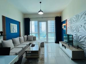 a living room with a couch and a tv at SKY NEST HOMES PRIVATE 1 BEDROOM APARTMENT DUBAI MARINA in Dubai