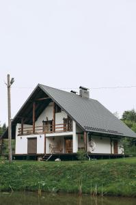 a large white house with a black roof at Dolyna Mykolaya in Migovo