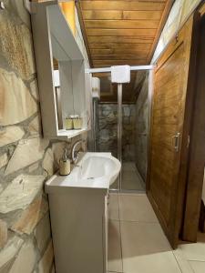 baño con lavabo y pared de piedra en Zeytindağı bungalow, en Mehmetalanı