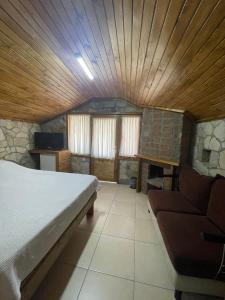 een slaapkamer met een bed en een bank in een kamer bij Zeytindağı bungalow in Mehmetalanı