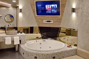 a bathroom with a large tub and a tv at Bedroom more than a bed in Zagreb