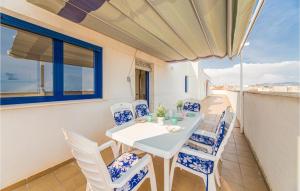 een eetkamer met een tafel en stoelen op een balkon bij Lovely Apartment In Torreblanca With Kitchen in Torreblanca