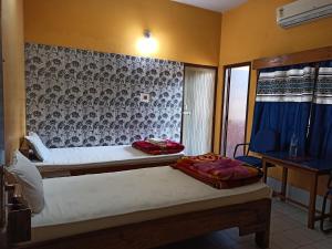 a bedroom with two beds and a wall at Hotel Aane in Itānagar