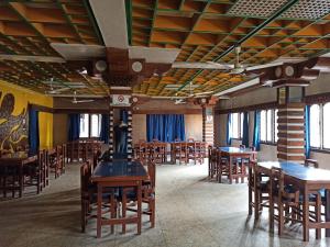 una sala da pranzo con tavoli e sedie in legno di Hotel Aane a Itānagar