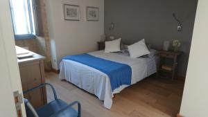 a bedroom with a bed with a blue comforter at Campo da Lúa 4 in Muros +11 photos