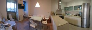 a kitchen with a table and chairs and a refrigerator at Campo da Lúa 4 in Muros