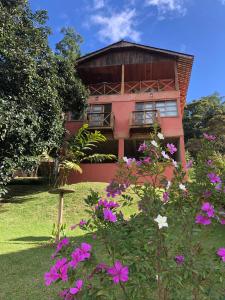 ドミンゴス・マルチンスにあるChalé Vista Azulのピンクの花が目の前に咲く建物