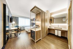 a hotel room with a bed and a bathroom at NH Brussels Airport in Diegem