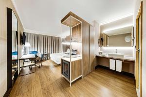 a hotel room with a bed and a bathroom at NH Brussels Airport in Diegem