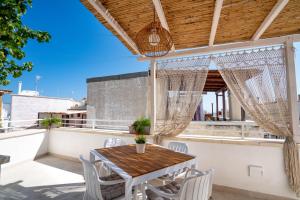a patio with a wooden table and chairs on a roof at Marianna 25 in Polignano a Mare