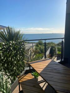 a wooden deck with a view of the ocean at The Bay house Apartments , shanklin in Shanklin