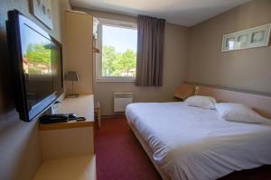 a hotel room with a bed and a flat screen tv at Hotel Ecluse 34 in Steinbourg