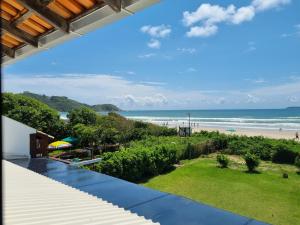 a view of the beach from the balcony of a house at Residencial Suites Mariscal in Bombinhas