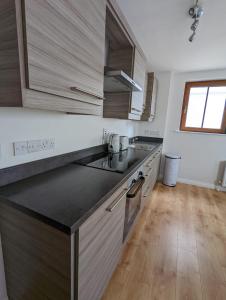 a kitchen with stainless steel appliances and wooden floors at Brooklands Central Apartment in Newcastle