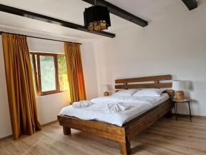 a bedroom with a bed and a window at Complex Dealu' Frumos in Întorsura Buzăului