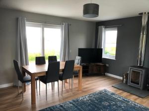 ein Esszimmer mit einem Holztisch und Stühlen in der Unterkunft Loch Caroy Bay Cottage in Ose + 7 Fotos