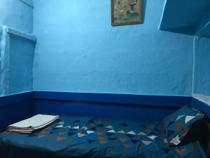 a bed in a room with a blue wall at Blue Stay Jodhpur in Jodhpur