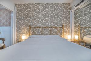- une chambre avec un lit et un mur recouvert de papier peint dans l'établissement Apartamento Centro Cordoba & Parking Gratuito, à Cordoue