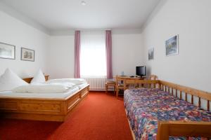 a hotel room with two beds and a desk at Hotel Brockenscheideck in Schierke