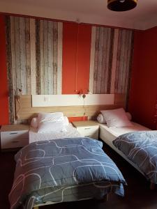Duas camas num quarto com paredes vermelhas em Gite La maison d'Odette em Saint-Georges-de-Mons