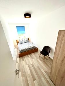 a small bedroom with a bed and a chair at KMHosting modern & gemütlich im Zentrum in Chemnitz