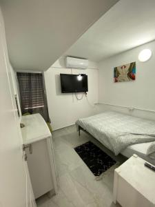 a bedroom with a bed and a flat screen tv at Levis house Eilat in Eilat