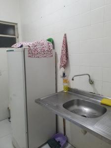 a kitchen with a sink and a refrigerator at Estudio no centro de campinas 26m² in Campinas