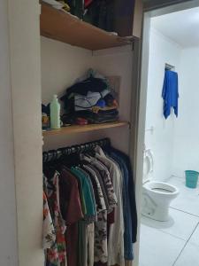 a closet with a bunch of clothes and a toilet at Estudio no centro de campinas 26m² in Campinas