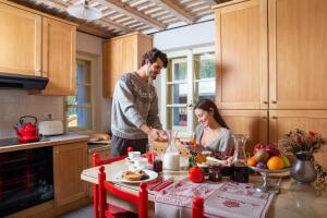 mężczyzna i kobieta przygotowujący jedzenie w kuchni w obiekcie QC House - Chalet con Sauna w mieście Santa Caterina Valfurva +21 zdjęć