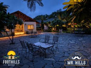 a patio with chairs and tables at night at Foothill Pushkar Resort in Pushkar