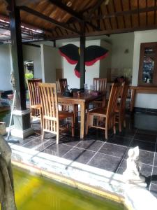a dining room with a table and some chairs at Taman Sari Tagtag in Sanur