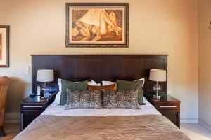 a bedroom with a large bed with two night stands at Kathu Gamagara Lodge in Kathu