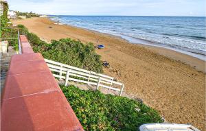 Blick auf einen Strand mit einem weißen Zaun in der Unterkunft Beautiful Home In Pozzallo With Wifi in Pozzallo + 10 Fotos