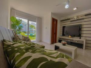 a living room with a couch and a flat screen tv at Casa Caldeira in Porto Seguro