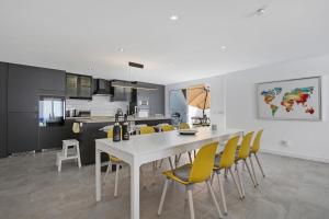a kitchen and dining room with a white table and yellow chairs at Villa Pacifica in Corralejo