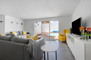 a living room with a couch and a tv at Villa Pacifica in Corralejo
