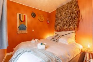 a bedroom with orange walls and a bed with two pillows at Be at Sea in Ostend all-in luxury apartment , outdoor pool, side seaview in Ostend