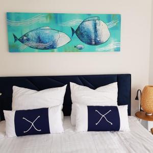a bedroom with a bed with a fish painting above it at PINEA BALTIC - 2 Zimmer Apartment mit Meerblick in Pobierowo