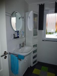 bagno bianco con lavandino e specchio di Haus Colonia a Walchum