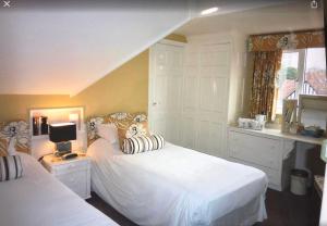 1 dormitorio con 2 camas blancas y ventana en Cransley Apart Hotel en Bournemouth