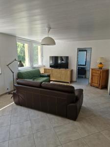 ein Wohnzimmer mit einem Sofa und einem TV in der Unterkunft La Colonie in Publier
