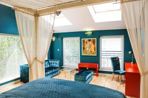 um quarto com paredes azuis e uma cama e cadeiras em Platan Apartments Premium em Cracóvia