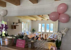 a dining room with a table with pink balloons at Ybrig Lodge in Unteriberg